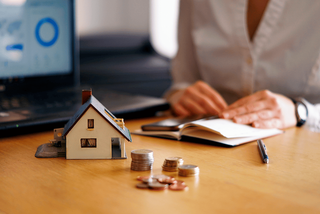 Table with house, coins and calculator for choosing a mortgage